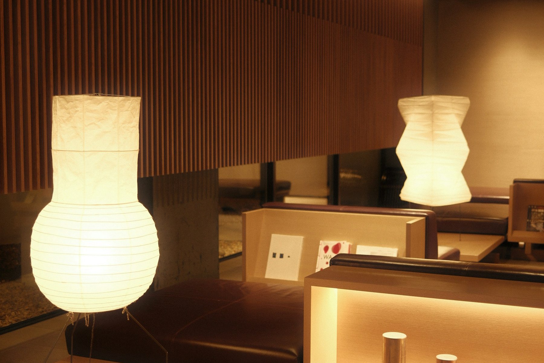 Hotel lounge with timber slats, low seating and softly glowing lamps.