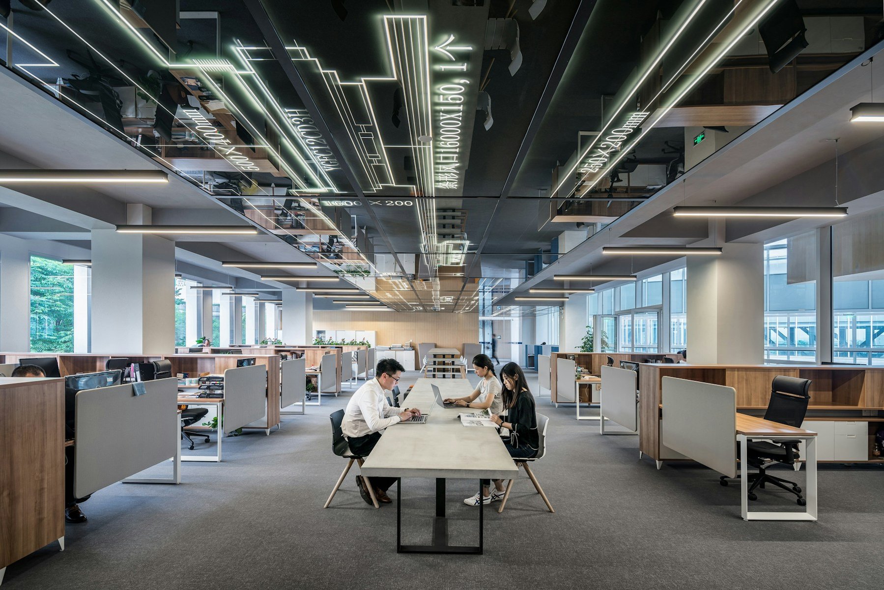 Open contemporary office with long work tables and generous daylight.